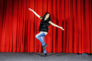 Angela Nicoletti tanssimassa punaisen näyttämöverhon edessä