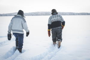 Kaksi miestä kävelee jäällä.