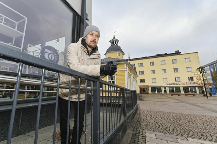 Lauri Kemppainen nojaamassa talon kaiteeseen Kajaanin torilla